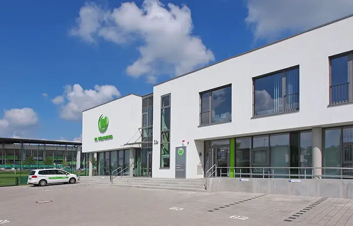 Modernes Bürogebäude mit VfL Wolfsburg Logo.