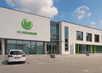 Moderner Bürokomplex mit dem Logo des VfL Wolfsburg.